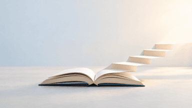 Offenes Buch, dessen Seiten sich in eine Treppe verwandeln und nach oben führen.